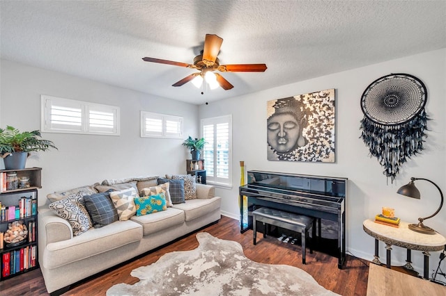 living room featuring a textured ceiling, ceiling fan, and dark wood-type flooring