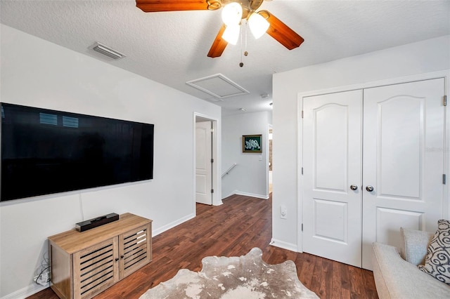 living room featuring a textured ceiling, dark hardwood / wood-style flooring, and ceiling fan