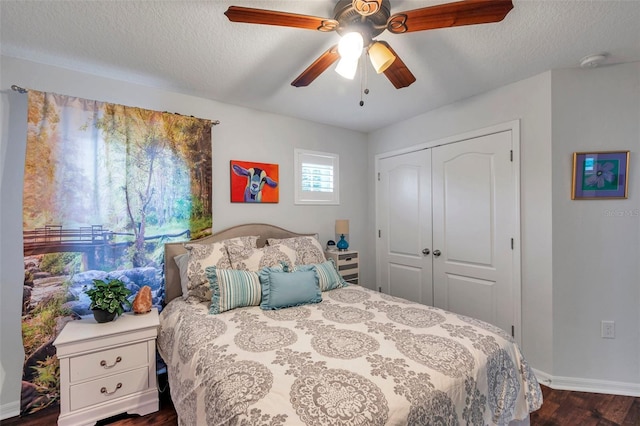 bedroom with ceiling fan, a closet, dark wood-type flooring, and a textured ceiling