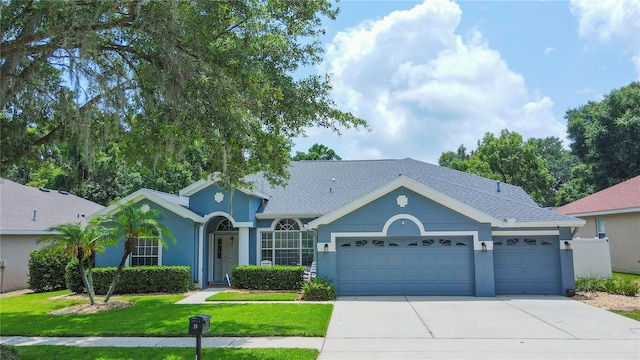 ranch-style house featuring a front yard and a garage