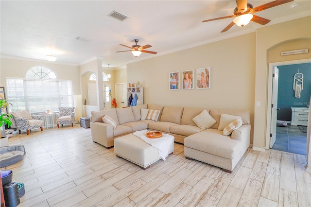 living room with a textured ceiling, ceiling fan, and ornamental molding