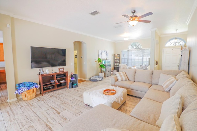 living room featuring ceiling fan, ornamental molding, and light hardwood / wood-style flooring