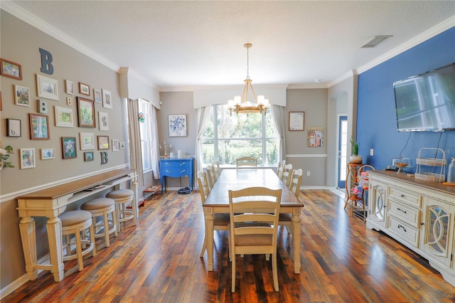 dining space with crown molding, dark hardwood / wood-style flooring, a textured ceiling, and an inviting chandelier