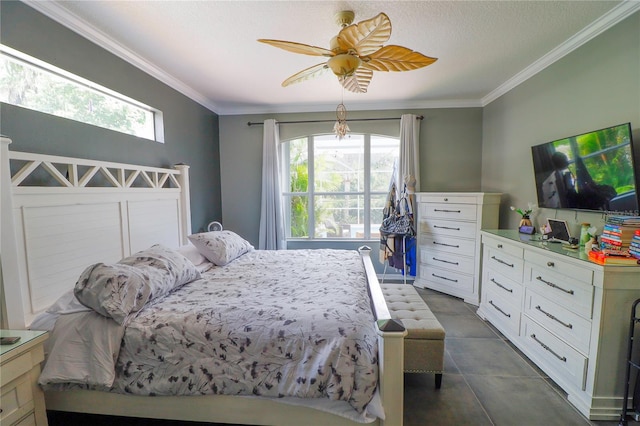 bedroom featuring ceiling fan, dark tile patterned floors, crown molding, and multiple windows