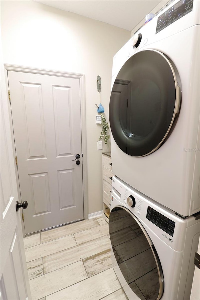 laundry room with stacked washing maching and dryer