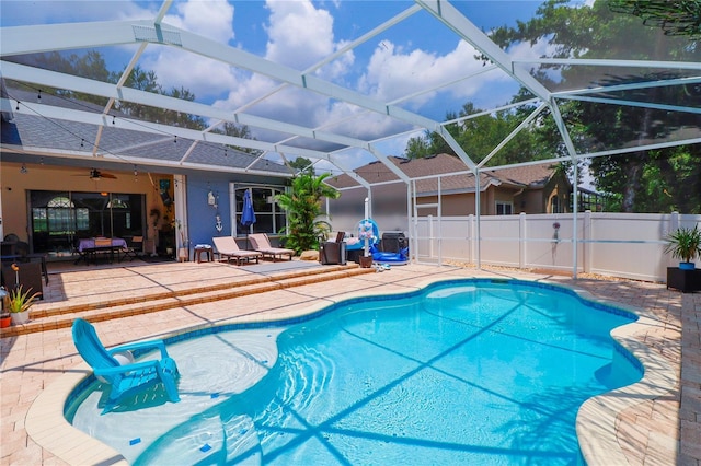 view of swimming pool featuring a lanai, ceiling fan, and a patio