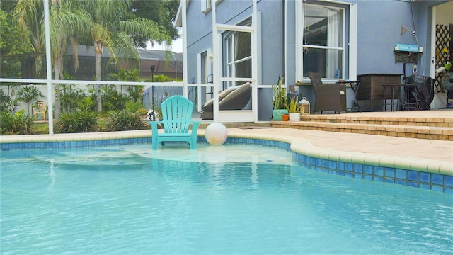 view of swimming pool featuring a lanai