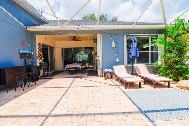 view of patio / terrace featuring glass enclosure and ceiling fan