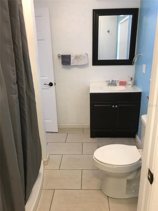 bathroom with a shower with curtain, vanity, toilet, and tile patterned flooring