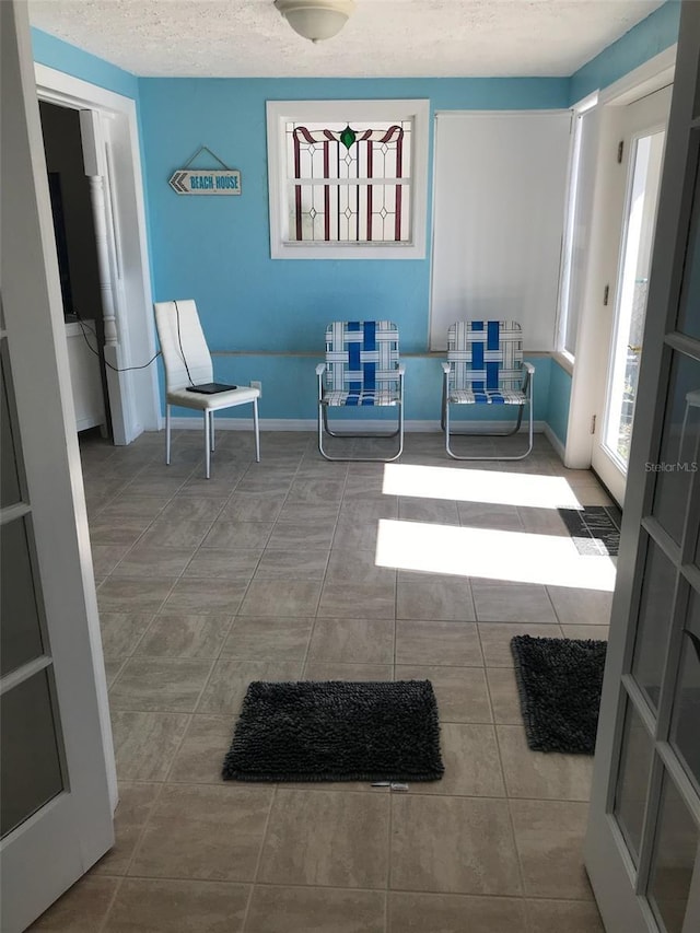 sitting room featuring tile patterned flooring and a textured ceiling