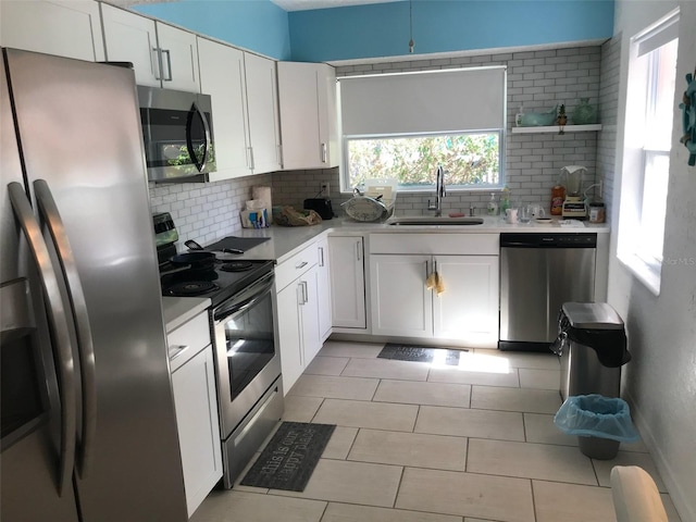 kitchen with white cabinetry, appliances with stainless steel finishes, sink, and decorative backsplash