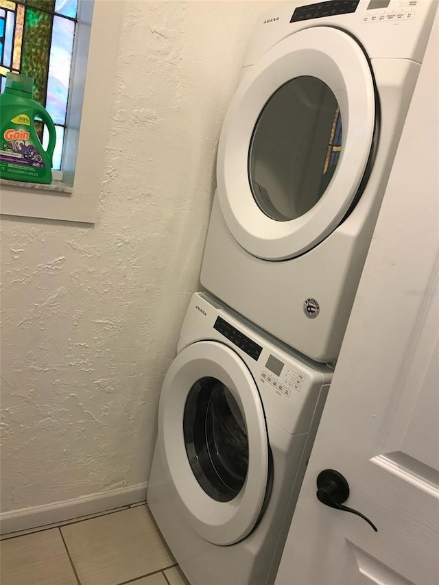 laundry area with tile patterned floors and stacked washer and clothes dryer