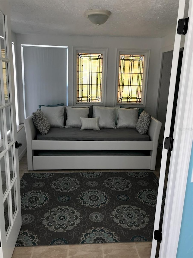 living room with a textured ceiling and french doors