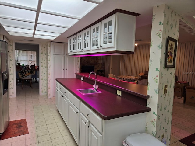 kitchen featuring white cabinetry, light tile patterned floors, stainless steel refrigerator with ice dispenser, and sink