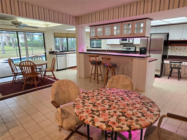 dining area with ceiling fan, sink, and a textured ceiling