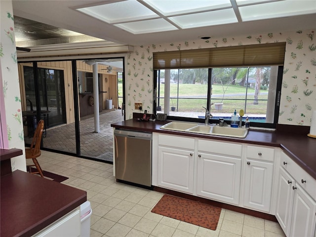 kitchen featuring sink, light tile patterned floors, white cabinets, and dishwasher