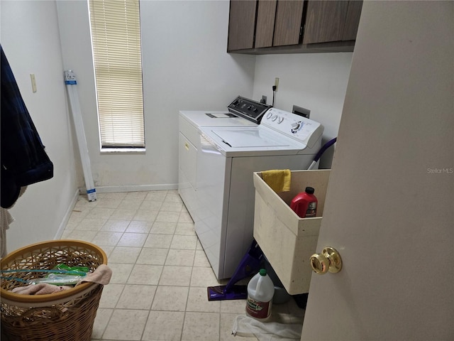 laundry room with washer and dryer and cabinets