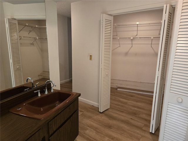 bathroom with a textured ceiling, hardwood / wood-style floors, and vanity