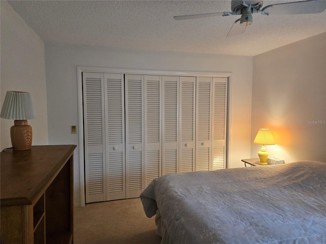 bedroom featuring ceiling fan, a closet, carpet, and a textured ceiling