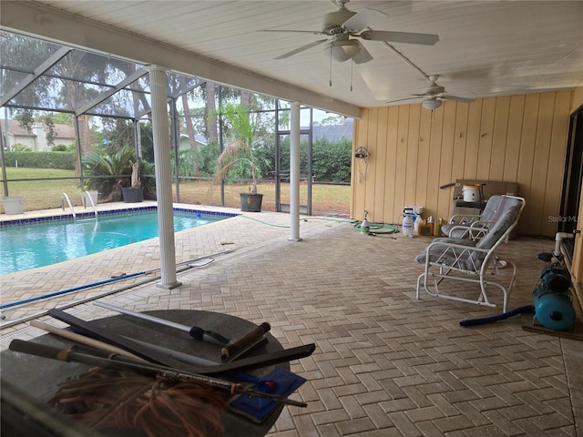 view of swimming pool featuring a patio area, ceiling fan, and glass enclosure