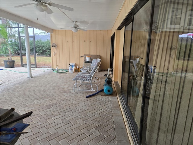 view of patio / terrace with ceiling fan and glass enclosure