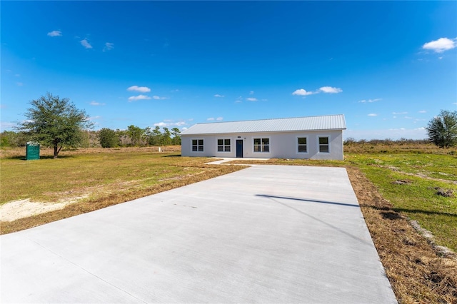 view of front of home with metal roof and a front yard