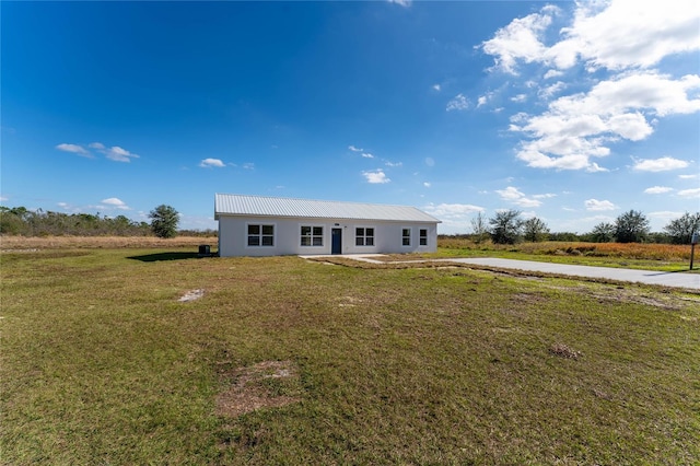 view of front of house with metal roof and a front yard