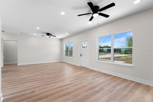 unfurnished living room with light wood-type flooring, baseboards, and recessed lighting