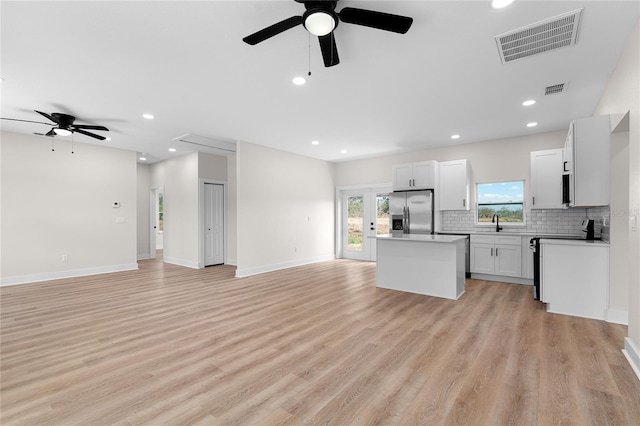 kitchen featuring a kitchen island, visible vents, open floor plan, electric stove, and stainless steel refrigerator with ice dispenser