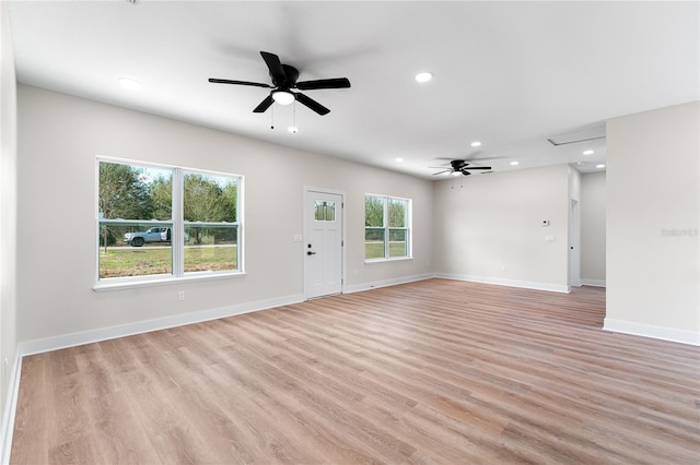 unfurnished living room featuring recessed lighting, light wood-style flooring, and baseboards