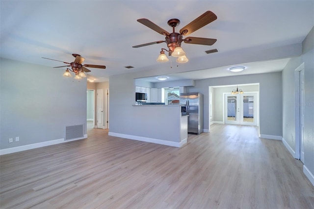 unfurnished living room with light hardwood / wood-style floors, french doors, and ceiling fan with notable chandelier