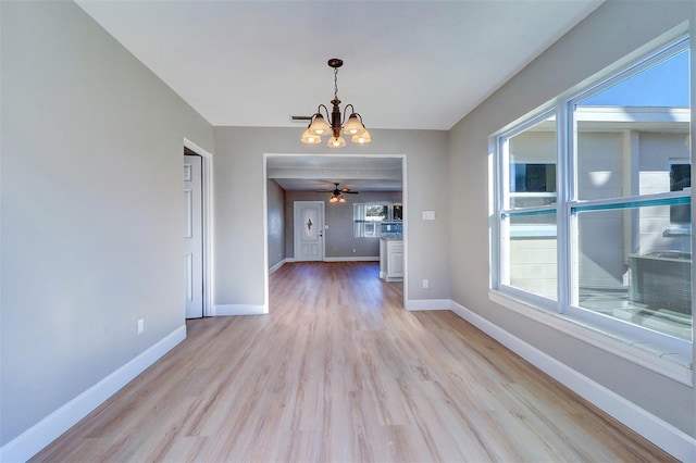 interior space with light hardwood / wood-style floors and ceiling fan with notable chandelier