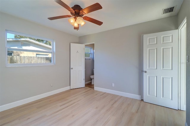 unfurnished bedroom with ceiling fan, light wood-type flooring, and ensuite bathroom