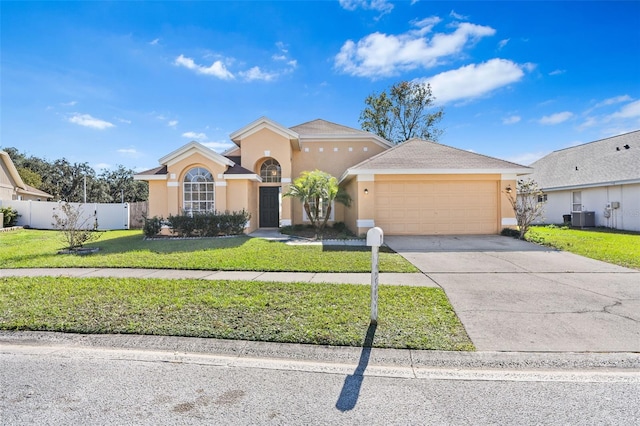 view of front of property with central AC unit, a garage, and a front lawn