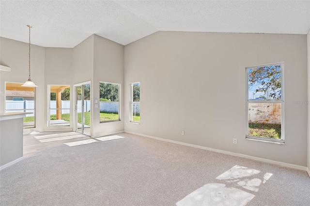 unfurnished room with high vaulted ceiling and light colored carpet