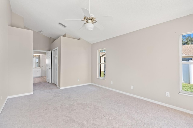 carpeted spare room with ceiling fan and lofted ceiling