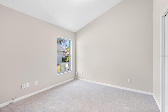 carpeted spare room featuring lofted ceiling