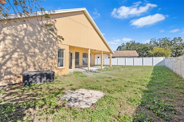 rear view of house featuring a lawn and a patio area