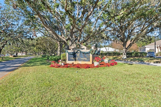 community sign featuring a lawn