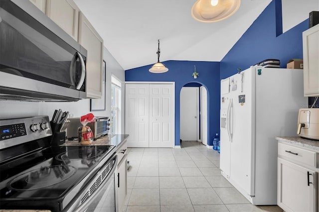 kitchen featuring lofted ceiling, white cabinets, hanging light fixtures, and appliances with stainless steel finishes