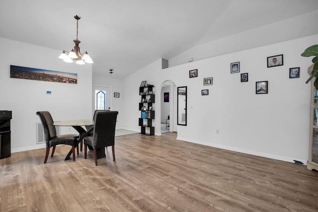 dining room featuring lofted ceiling, an inviting chandelier, and hardwood / wood-style floors