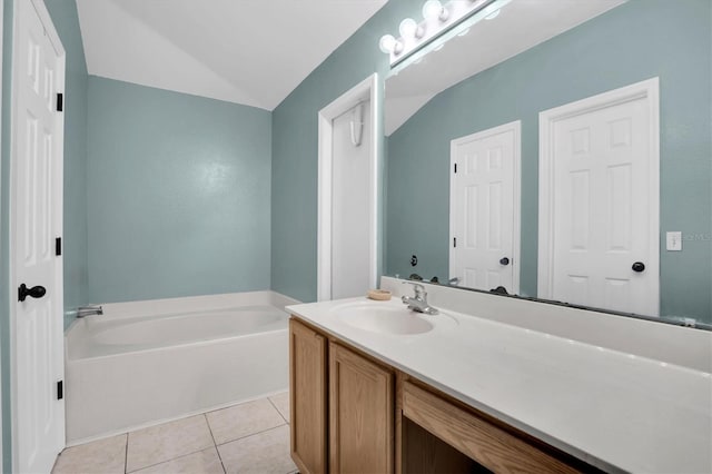 bathroom with vanity, a tub to relax in, lofted ceiling, and tile patterned floors