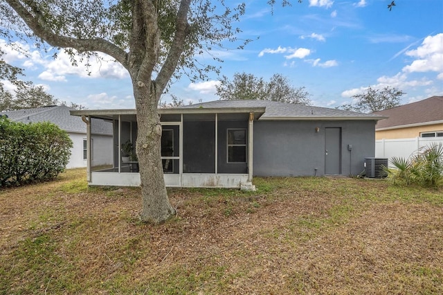 rear view of house featuring a yard, cooling unit, and a sunroom