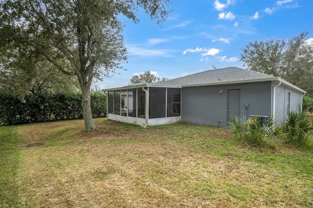 rear view of property featuring a sunroom and a lawn