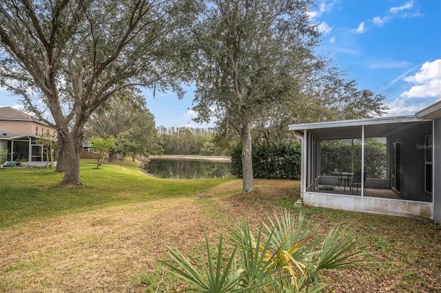 view of yard with a sunroom and a water view