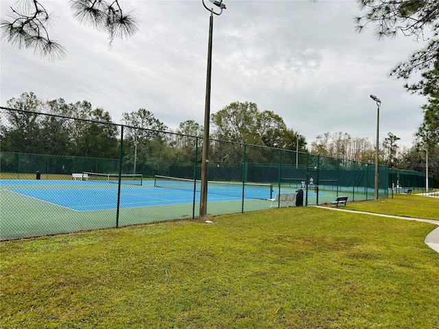 view of tennis court with a lawn