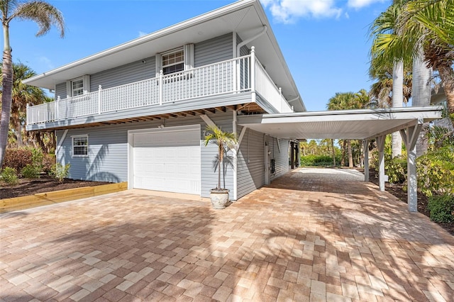 view of property featuring a garage, a carport, and a balcony