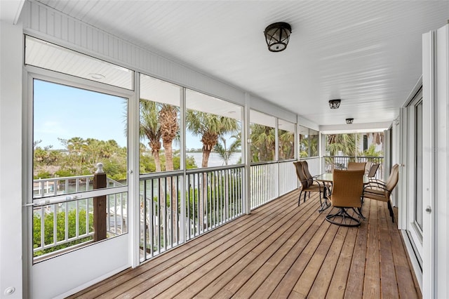 sunroom featuring a water view