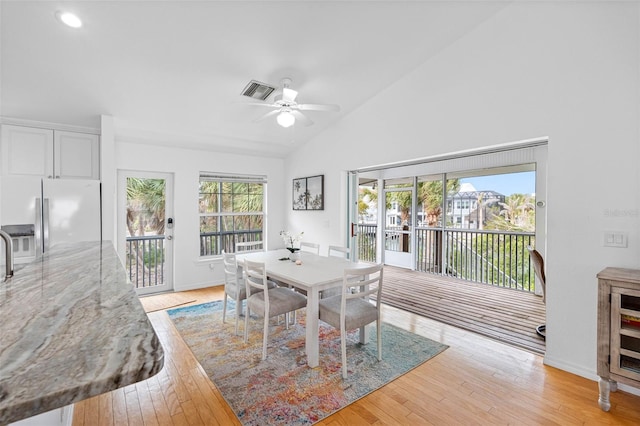 dining area featuring ceiling fan, high vaulted ceiling, and light hardwood / wood-style floors