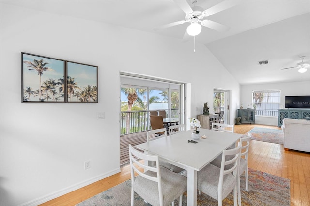 dining room with lofted ceiling, ceiling fan, and light wood-type flooring